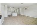 Spacious living room with tile flooring and neutral paint, flowing seamlessly into the updated kitchen at 9259 Marler Rd, Spring Hill, FL 34608