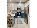 Well-equipped kitchen with stainless steel appliances and stylish blue and white cabinets at 10824 Quickwater Ct, Riverview, FL 33569