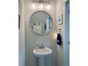 Charming powder room with pedestal sink, decorative mirror, and neutral paint at 10824 Quickwater Ct, Riverview, FL 33569