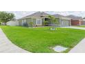 Charming home boasting a lush front lawn, attractive landscaping, and a convenient two-car garage at 11913 Butler Woods Cir, Riverview, FL 33579