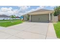 Charming home featuring a two-car garage, lush lawn, and well-maintained driveway at 11913 Butler Woods Cir, Riverview, FL 33579