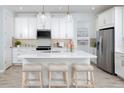 Bright kitchen featuring white cabinetry, stainless steel appliances, and a center island with seating at 12586 Somatic Ct, Venice, FL 34293