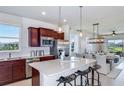 Bright kitchen features stainless appliances, a large island, and seamless flow to dining area at 13740 Rocky Pine Pl, Spring Hill, FL 34610