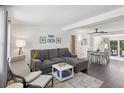 Bright living room with a comfortable gray sectional sofa and open access to the dining area at 1438 Poinciana Dr, Clearwater, FL 33764