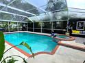 Enclosed pool and hot tub area with outdoor seating and privacy landscaping for relaxation and entertaining at 14509 Thornfield Ct, Tampa, FL 33624