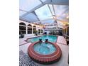 Inviting screened-in pool and spa area with string lights for evening ambiance at 14509 Thornfield Ct, Tampa, FL 33624