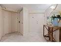 Hallway entrance with beige tile and wooden table with ocean-themed decoration and mirror at 1520 Gulf Blvd # 1502, Clearwater Beach, FL 33767