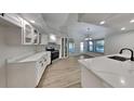 Modern kitchen with white cabinets, stainless steel appliances, quartz countertops, and updated fixtures at 23344 Van Buren Ave, Punta Gorda, FL 33980