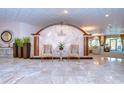 Elegant lobby featuring a marble floor, two chairs, and a decorative wall with 'The Cloisters' logo at 288 Beach Ne Dr # 12C, St Petersburg, FL 33701