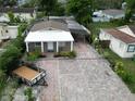 Overhead view of a quaint single-story home with brick driveway and mature landscaping at 3110 W Haya St, Tampa, FL 33614