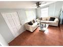 Cozy living room featuring a comfortable sofa, glass-top coffee table and tiled floor at 3110 W Haya St, Tampa, FL 33614