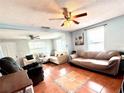 Spacious living room featuring tile flooring, ceiling fans and natural light at 3110 W Haya St, Tampa, FL 33614