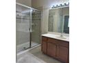 Bathroom featuring a glass-enclosed shower and vanity with modern fixtures and lighting at 3641 Parkridge Cir # 10-103, Sarasota, FL 34243