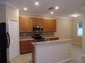 Eat in kitchen with stainless steel appliances, wood cabinetry and countertop seating at 3641 Parkridge Cir # 10-103, Sarasota, FL 34243