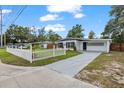 Attractive home exterior with concrete driveway, landscaped lawn, modern white picket fence and updated facade at 4020 N Falkenburg Rd, Tampa, FL 33610
