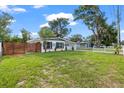 Landscaped front yard featuring a modern home, wooden fence, and healthy green grass at 4020 N Falkenburg Rd, Tampa, FL 33610