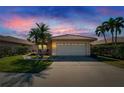 Home at dusk featuring a tile roof, well-maintained landscaping, and an attached two-car garage at 4415 Muirfiled Dr, Bradenton, FL 34210