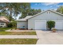 Charming single-story home with light gray siding and a single-car garage, featuring an inviting driveway at 4532 Cedarwood Village Dr, Tampa, FL 33624