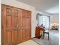 A view of the entryway with a wooden double door, leading to a living space with carpet and a window at 950 Waverly St, Oldsmar, FL 34677