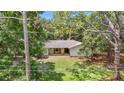 A quaint single-story home nestled among mature trees with a well-kept lawn and stone pillar accents at 950 Waverly St, Oldsmar, FL 34677