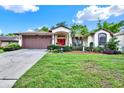 Charming single-story home features a beautiful red front door and a well-manicured lawn at 10732 Drummond Rd, Tampa, FL 33615
