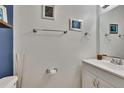 Clean half bathroom with white vanity, framed mirror, and nautical decorations at 110 114Th Ne Ter # 110, St Petersburg, FL 33716