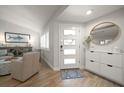 Bright entryway with wood floors, modern shoe storage, and a decorative round mirror at 11763 Saree Ct, Largo, FL 33778