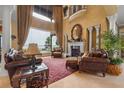 Elegant living room featuring high ceilings, large windows, a fireplace, and comfortable seating at 12125 Stonelake Ranch Blvd, Thonotosassa, FL 33592