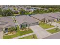 Suburban home boasts a well-kept lawn, a two-car garage, and proximity to neighboring houses and greenery at 13527 Willow Bluestar Loop, Riverview, FL 33579