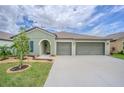 Inviting home exterior featuring a two-car garage, lush landscaping, and a welcoming front entrance at 13527 Willow Bluestar Loop, Riverview, FL 33579