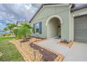 Charming front entrance with decorative landscaping, including a welcoming arched entryway and stone accents at 13527 Willow Bluestar Loop, Riverview, FL 33579