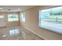 Bright living room featuring sleek, light-colored tile flooring, and views to the outside from the windows at 1407 Coral Ridge Dr, Punta Gorda, FL 33950