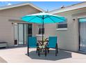 Cozy back porch area with outdoor seating, an umbrella, and sliding glass doors for easy access at 1675 E Grovehill Rd, Palm Harbor, FL 34683
