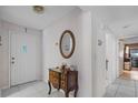 Inviting foyer featuring tiled floors, vintage furniture and decor and a door with decorative stained glass at 1811 49Th N St, St Petersburg, FL 33710