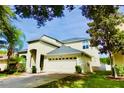 Beautiful home boasting a two-car garage, lush green lawn and elegant architectural details at 18439 Red Willow Way, Land O Lakes, FL 34638