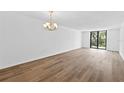 An open living room with laminate flooring and sliding glass door to the balcony at 201 W Laurel St # 308, Tampa, FL 33602