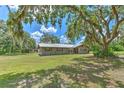 Spacious single-story home with mature oak tree coverage and a large front yard at 2610 Crestview Rd, Wimauma, FL 33598