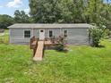 Exterior of a single-story home with a ramp leading to the front door and deck at 26223 Chianina Dr, Wesley Chapel, FL 33544