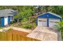 Aerial shot of blue home with a detached two-car garage and landscaped backyard at 301 Kingston S St, St Petersburg, FL 33711