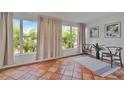 Bright sunroom featuring red-tiled floors, large windows and views of lush greenery at 301 Kingston S St, St Petersburg, FL 33711