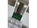 Patterned tile leading to front porch with artificial turf and opened door to home interior at 368 6Th Nw St, Largo, FL 33770
