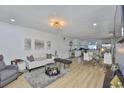 Bright living room with contemporary decor, including a white sofa, glass coffee table, and open layout to the kitchen at 3836 N Lake Dr # 121, Tampa, FL 33614