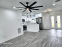 Bright, open kitchen featuring white cabinets, modern lighting, stainless steel appliances, and stylish gray flooring at 8524 Fish Lake Rd, Tampa, FL 33619