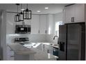 Close-up of a well-lit kitchen showcasing white cabinets, stainless steel appliances, and marble countertops at 8524 Fish Lake Rd, Tampa, FL 33619