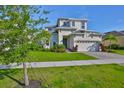 Two-story home featuring manicured lawn, beautiful landscaping, and a two car garage at 955 Signet Dr, Apollo Beach, FL 33572