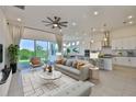 Open-concept living room featuring modern decor, a ceiling fan, and sliding glass doors at 955 Signet Dr, Apollo Beach, FL 33572