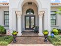 Elegant front entrance featuring decorative columns, a beautiful door, and manicured landscaping at 1014 Stella Vara Dr, Lutz, FL 33548