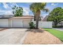 View of garage and front exterior featuring a well maintained garden and new driveway at 103 E Davis Blvd # B, Tampa, FL 33606