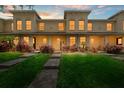Charming townhome featuring a well-manicured lawn, walkway, and facade illuminated by warm, inviting lights at 10947 Brickside Ct, Riverview, FL 33579