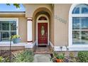 Close-up of front door features a red door and arched entryway at 11550 Wellman Dr, Riverview, FL 33578